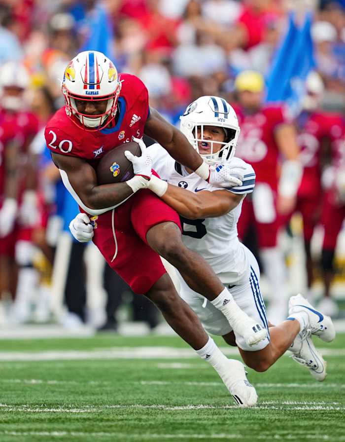 Kansas Jayhawks running back Daniel Hishaw Jr. (20) is tackled by Brigham Young Cougars linebacker Ace Kaufusi (18) during the second half at David Booth Kansas Memorial Stadium.